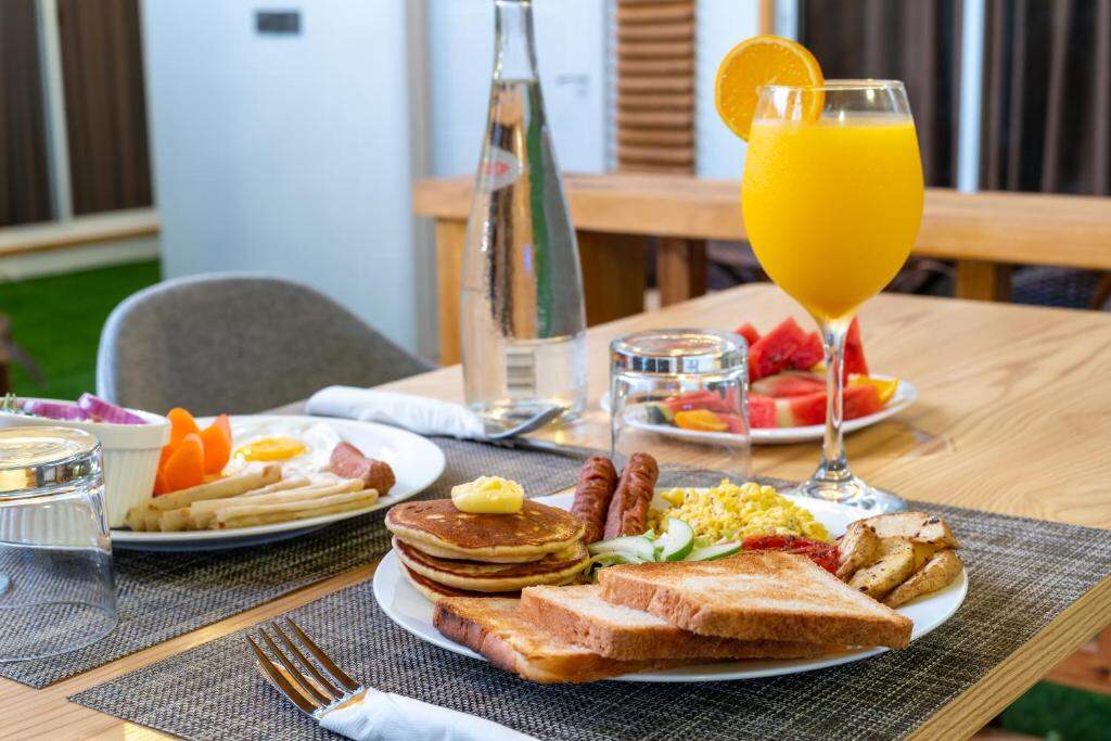 Breakfast with pancakes, eggs, toast, fresh fruit and orange juice served in the garden at Tropico Villa